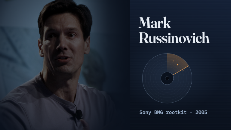 Mark Russinovich phát biểu trên sân khấu trong bức ảnh được làm tối, ở bên trái bìa nền xanh lam đậm có hình đường viền đĩa CD với một vạch quét màu cam chạy ngang và các dòng chữ “Mark Russinovich”, “Sony BMG rootkit · 2005”.