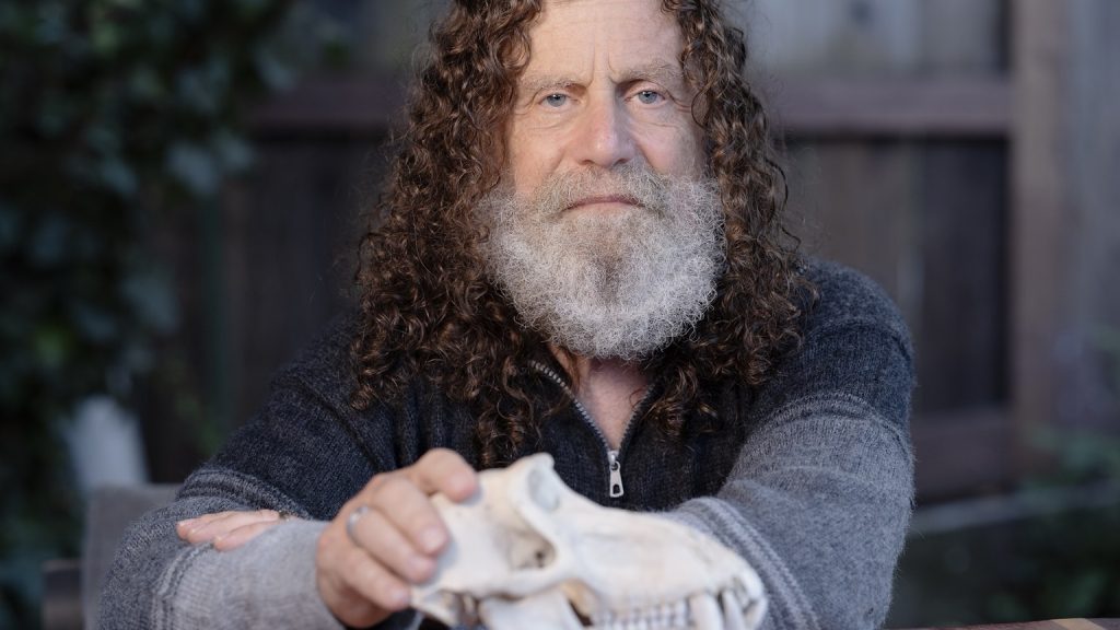 Chân dung nhà khoa học thần kinh Stanford Robert Sapolsky với tóc xoăn dài và râu trắng, chụp năm 2023.